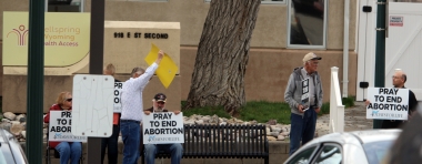 Pro-life Casper residents pray and hold signs on the sidewalk in front of Wellspring Health Access, the abortion facility that opened on Second Street in Casper, Wyo., in April.